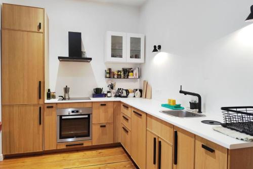 une cuisine avec des armoires en bois et un évier dans l'établissement Beautiful T3 in the historic heart of Bordeaux, à Bordeaux