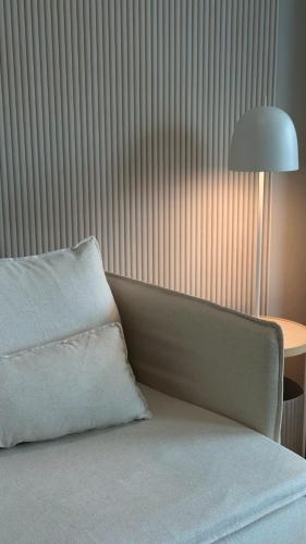 Cama con almohada junto a una mesa con lámpara en Winn's Hotel Bentong, en Bentong