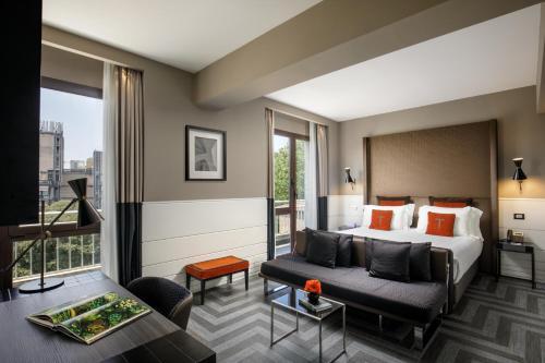 una camera d'albergo con un letto e un divano di The Tribune, part of JdV by Hyatt a Roma