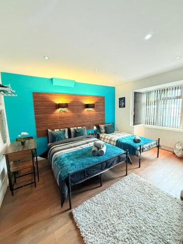 a bedroom with two beds and a blue wall at Chiswick Guest Rooms in London