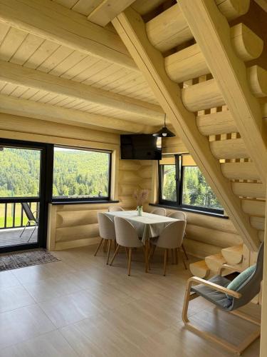 a dining room with a table and chairs and windows at St Hubertus eco complex 
