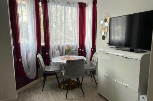 une salle à manger avec une table avec des chaises et une télévision dans l'établissement Studio At 200m From Beach Residence With Pool, à Cannes