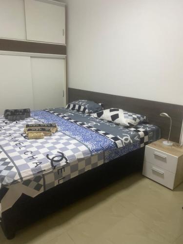 a bedroom with a bed with a blue and white comforter at Studio Gala in Požarevac