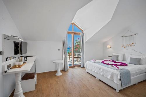 a white bedroom with a white bed and a sink at Kumluk Hotel in Datca
