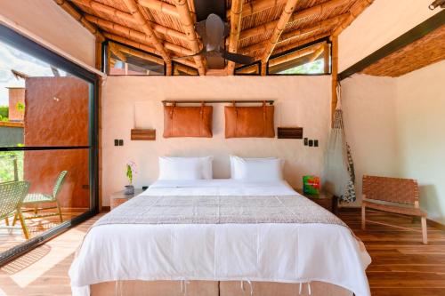 a bedroom with a bed in a room with windows at Kawa Bamboo Retreat in Pereira