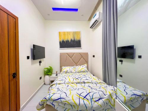 a bedroom with a bed and a tv at Sage View House in Lekki