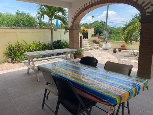 a table and chairs on a patio with a table and a bench at Casitas Las Palmas - Coral Azul in Punta Mita