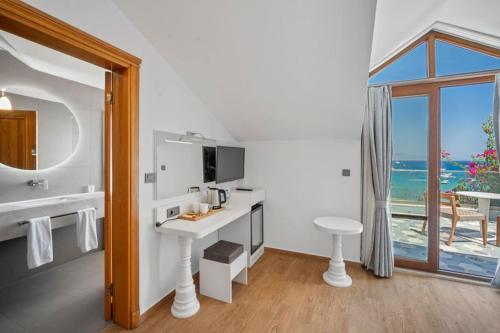 a white bathroom with a desk and a window at Kumluk Hotel in Datca