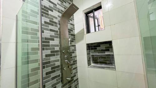 a shower with a glass door and a window at Sage View House in Lekki