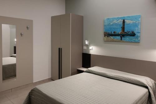 a bedroom with two beds and a painting on the wall at Affittacamere Kalòs in Reggio Calabria