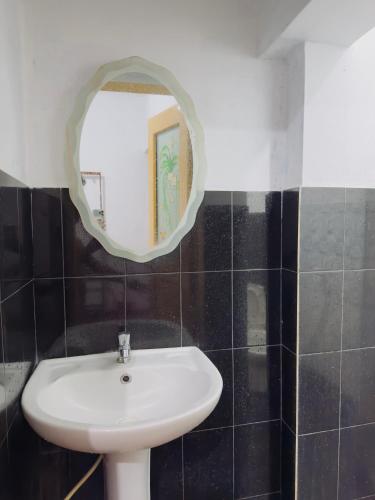 a bathroom with a white sink and a mirror at New Pearl Guest Inn in Badulla