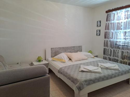 a bedroom with a bed and a couch at Berto in Nerezine