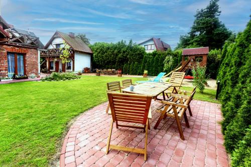 a table and chairs on a brick patio at Apartamenty Heweliusz House in Stegna