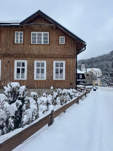 a house with snow covered plants in front of it at Chalupa JFD, Josefův Důl in Josefuv dul
