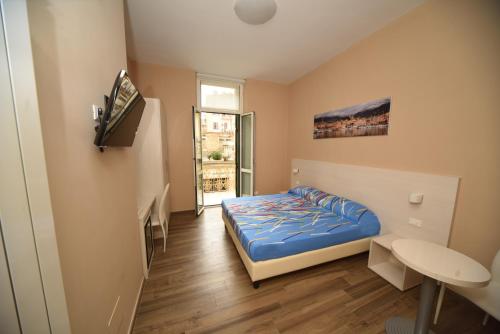 Habitación pequeña con cama y ventana en Gioberti House, en San Remo