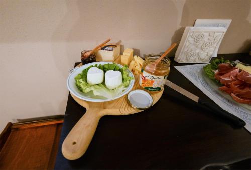 a table with a wooden spoon and a bowl of cheese and lettuce at Antico Casale Cesenatico B&B in Cesenatico