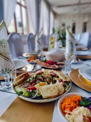 a long table with plates of food on it at Hotel Galicja in Ulanów