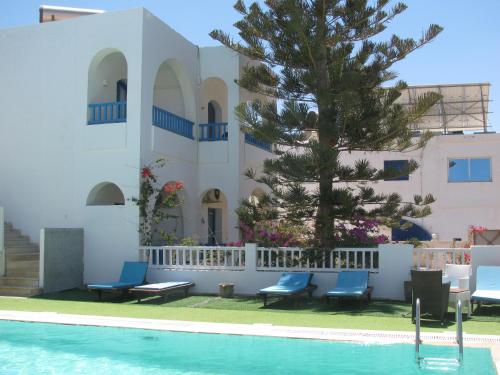 a house with a swimming pool in front of a building at Dar Salem in Djerba
