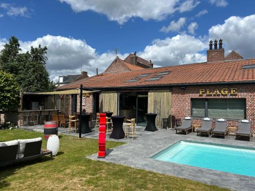 een gebouw met een zwembad in de tuin bij Gîte à la ferme in Houplin-Ancoisne