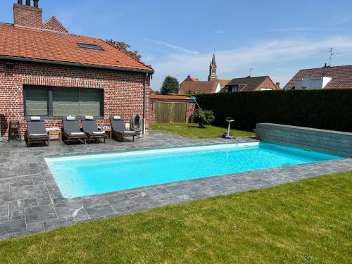 een zwembad in een tuin naast een huis bij Gîte à la ferme in Houplin-Ancoisne