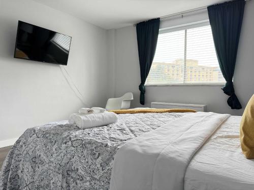 a bedroom with a large bed with a tv on the wall at Downtown New-Built Roof-top balcony City View 525Pkwy in Atlanta