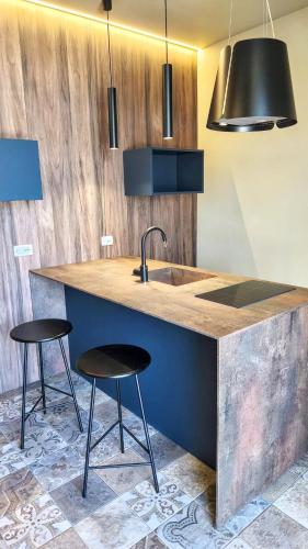 a kitchen with a counter with two stools and a sink at Casa Lombardo in Birgi Vecchi