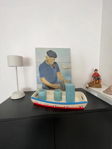 a table with a surfboard with a painting on it at A due passi dal mare 2023 in Nettuno