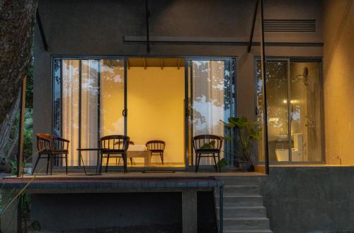 a house with chairs and a table on a porch at The Smiling Leaf in Ambalangoda
