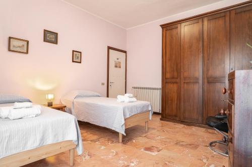une chambre avec deux lits et une armoire en bois dans l'établissement Casa Dei Ricci, à Lucques