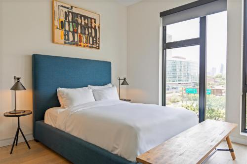 a bedroom with a large bed with a blue headboard at Sosuite at The Onyx - Museum District in Philadelphia