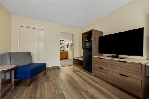 a living room with a flat screen tv on a dresser at Best Western Center Pointe Inn in Branson