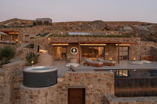 a stone house with a hot tub in the yard at GkF Luxury Villas in Naxos Chora