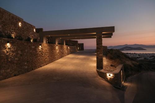 a bench on the side of a wall with lights at GkF Luxury Villas in Naxos Chora