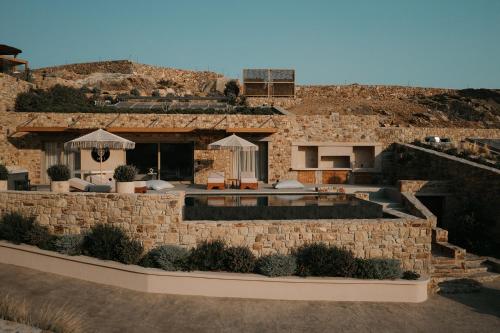 a stone house with a pool in front of a building at GkF Luxury Villas in Naxos Chora