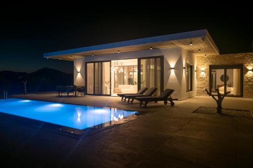 a villa with a swimming pool at night at Antiope Retreat in Pitsidia