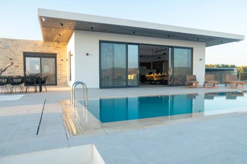 a swimming pool in front of a house at Antiope Retreat in Pitsidia