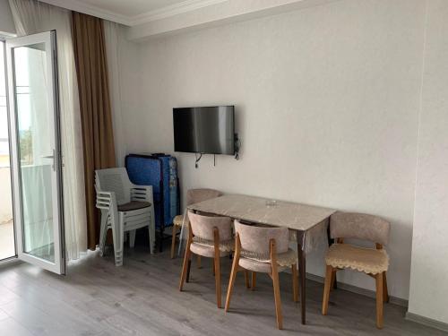 a dining room with a table and chairs and a tv on the wall at Astara Terrace 2-3 in Astara