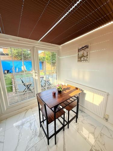 a dining room with a table and a large window at Chiswick Guest Rooms in London