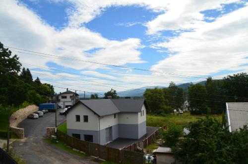 a white house on a hill with a fence at Apartament u Gabrysi in Piechowice