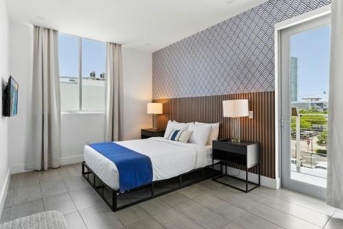 a bedroom with a bed and a large window at MILLA South Beach in Miami Beach