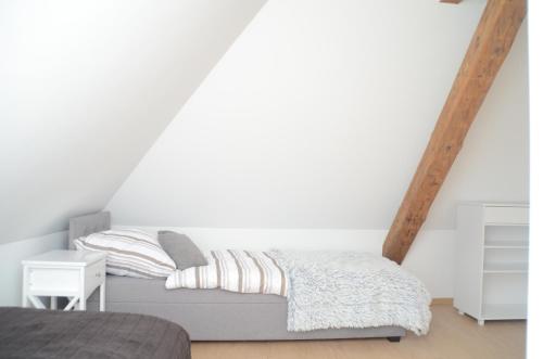 a bedroom with a bed and a white wall at Apartament u Gabrysi in Piechowice