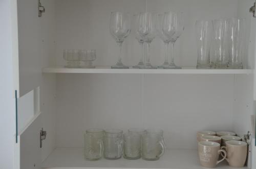 a shelf with glasses and mason jars on it at Apartament u Gabrysi in Piechowice