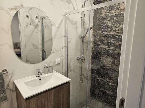 een badkamer met wastafel en douche met spiegel bij Villa Júlia, Mountain retreat in Santa Cruz