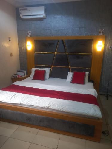 a bedroom with a large bed with red pillows at Ogoni Kitchen Hotel in Port Harcourt