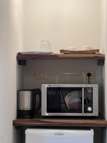 un forno a microonde su una mensola con una macchinetta del caffè di Los Plátanos cabañas & suites a Moreno