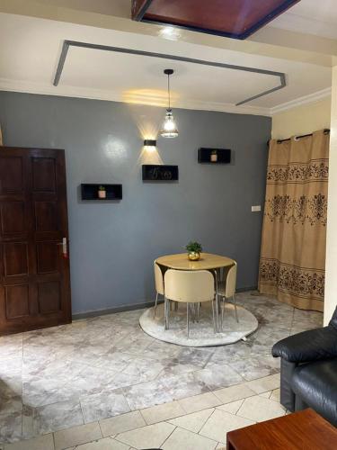 a table and chairs in a living room at Résidence H - Ekoumdoum in Yaoundé