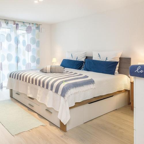 a bedroom with a large white bed with blue pillows at Im Guggenbühl in Überlingen