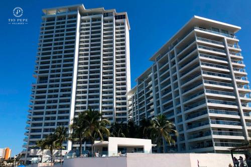 a tall building with palm trees in front of it at Harbor Puerto Vallarta 1006 in Puerto Vallarta
