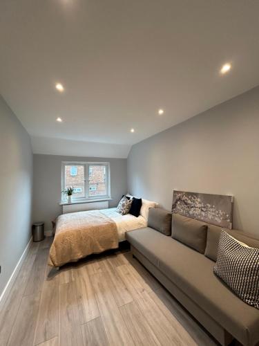 a bedroom with a bed and a couch at Modern Rooms - Walk to Kings Cross - Central in London