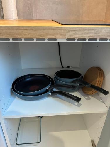 two frying pans sitting on top of a stove at Studio number 5 in Pantin